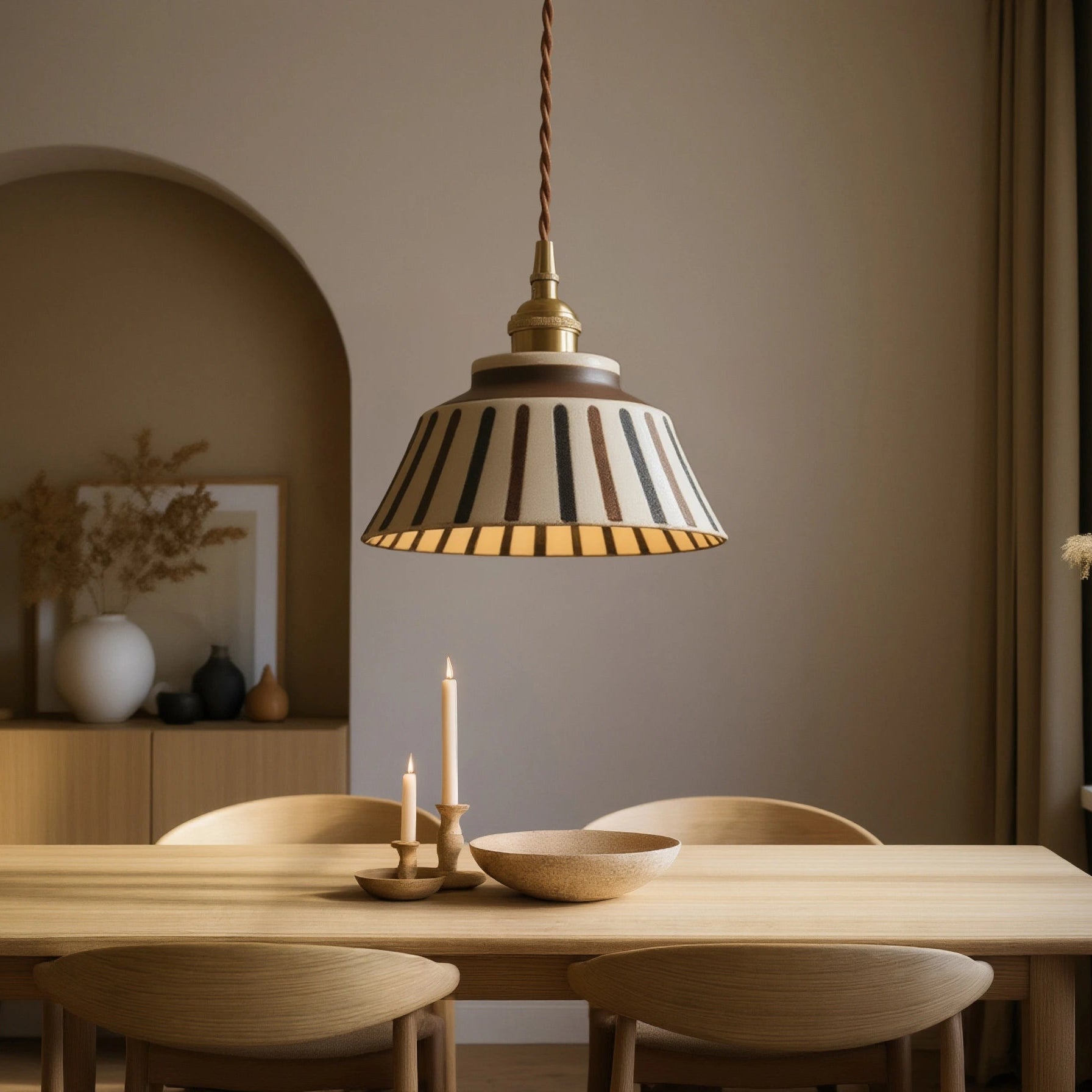 Dining room with wooden table and chairs, pendant light, and window with decorative elements.